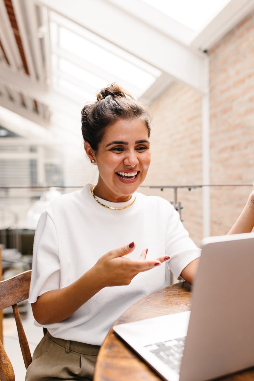 Woman laughing during a virtual anxiety therapy session from home